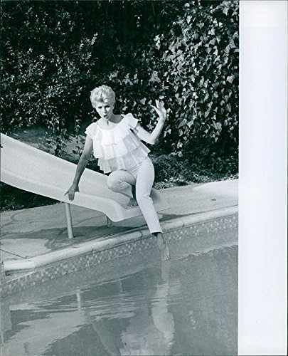 Реколта снимка Барбара Андерсън, седнала на бортике басейна.